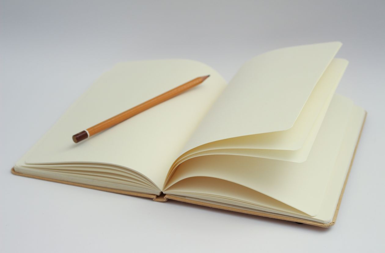 Open notebook and pencil for writing a design brief that controls logo design cost in Syria